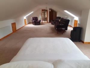 um quarto grande com uma cama e cadeiras em Urkers' Guest Accommodation em Crossmaglen