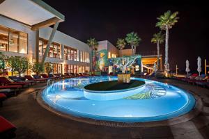 a large pool with a fountain in the middle of a building at Fuwairit Kite Beach, Tapestry Collection By Hilton in Fuwayriţ