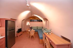 cocina y sala de estar con sofá y mesa en PhiloXenia Traditional Apartments, en Chios