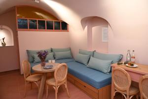- un canapé dans une pièce avec une table et des chaises dans l'établissement PhiloXenia Traditional Apartments, à Chios