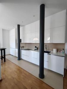 a kitchen with white cabinets and a black pole at Apartamento Moderno en el Centro Navarrete in Navarrete