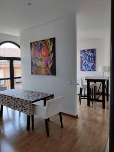 a dining room with a table and chairs and a painting at Apartamento Moderno en el Centro Navarrete in Navarrete +6 photos