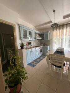 cocina con armarios azules, mesa y sillas en Grazy House, en Marina di Modica