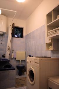 y baño con lavadora y aseo. en Kuća za odmor LEON, en Klenovica
