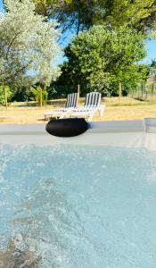 una piscina con una silla y una piscina de agua en La Tranquillette, en Villecroze