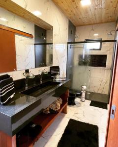 La salle de bains est pourvue d'un grand lavabo et d'une douche. dans l'établissement Cabana Luar da Serra, à Urubici