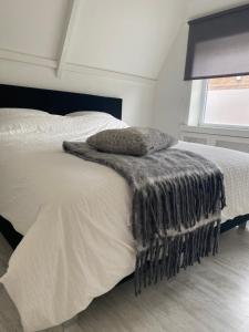 - une chambre avec un lit, une couverture et une fenêtre dans l'établissement Free Fly Loft Drachten, à Drachten