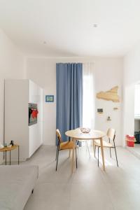 ein weißes Wohnzimmer mit einem Tisch und Stühlen in der Unterkunft Casa Ancora TownHouse in Catania