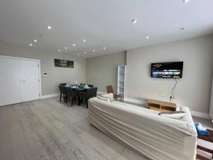 a living room with a white couch and a table at Star London Bell Lane 3-Bed Oasis with Garden in Hendon