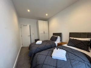 2 camas en una habitación con 2 camas individuales en Star London Bell Lane 3-Bed Oasis with Garden en Hendon