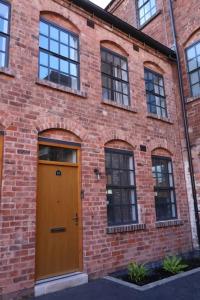 ein Backsteingebäude mit einer braunen Tür und Fenstern in der Unterkunft Modern house in Birmingham in Birmingham