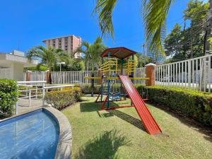 a playground with a slide next to a pool at Condomínio Vivence in Fortaleza