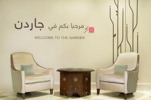 two chairs and a table with a sign welcomingelcome to the garden at Hilton Garden Inn Dubai Al Mina - Jumeirah in Dubai