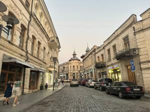 a city street with cars parked on a cobblestone street at Guest House Memo at the center of kutaisi in Kutaisi
