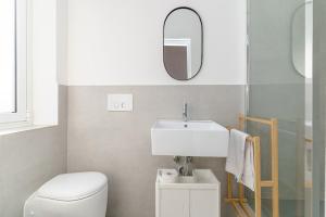 ein Badezimmer mit einem WC, einem Waschbecken und einem Spiegel in der Unterkunft Casa Ancora TownHouse in Catania