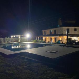 - une piscine en face d'une maison la nuit dans l'établissement Caminito del Rey Piscina Campo fútbol 20 adultos, à Alora