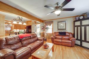 a living room with leather furniture and a ceiling fan at 7 Mi to Beech Mountain Skiing Home with Fire Pit in Banner Elk