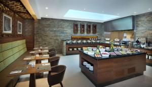 ein Restaurant mit Tischen und Stühlen und einem Buffet in der Unterkunft Hilton Garden Inn Dubai Al Muraqabat - Deira in Dubai
