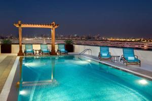 a swimming pool on the roof of a building at Hilton Garden Inn Dubai Al Muraqabat - Deira in Dubai