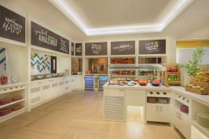 a large kitchen with a counter with fruits and vegetables at Hampton By Hilton Dubai Airport in Dubai