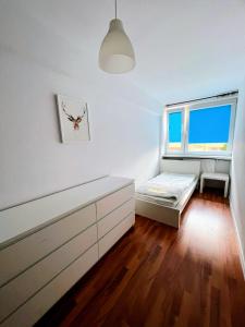 biały pokój z łóżkiem i oknem w obiekcie Ursus Rooms-Self Check-in w Warszawie