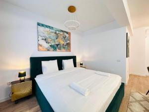 a bedroom with a large bed with white sheets at RHUM B02 - Liberty in Bucharest