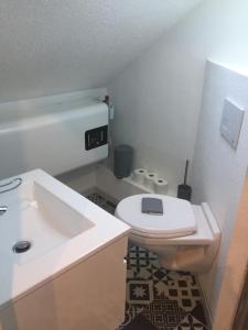 a bathroom with a white toilet and a sink at Studio moderne, étage 3, avec literie de qualité prémium in Belfort