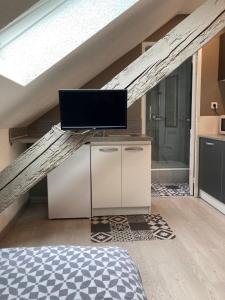 a room with a bed and a television in a attic at Studio moderne, étage 3, avec literie de qualité prémium in Belfort