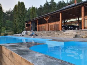 an outdoor swimming pool with a house at Гостинна садиба Пілігрім in Surzhentsy