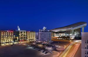 a city at night with cars parked in a parking lot at Hilton Garden Inn Dubai, Mall Avenue in Dubai