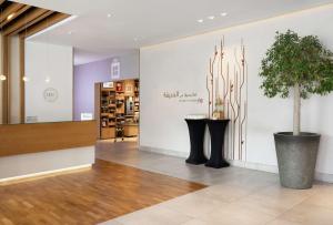 a lobby with a potted plant and a wall at Hilton Garden Inn Dubai, Mall Avenue in Dubai