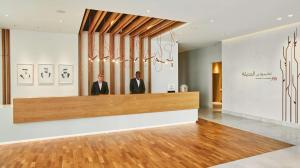 two men standing behind a counter in a lobby at Hilton Garden Inn Dubai, Mall Avenue in Dubai