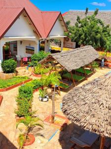 um resort com um edifício com telhado de palha em Mimi na wewe villa em Nungwi
