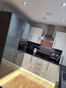 a kitchen with stainless steel appliances and wooden floors at london most famous in Dartford