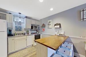 cocina con armarios blancos y encimera de madera en Misty Harbor 118 en Gilford