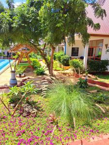 un jardín con flores rosas frente a una casa en Mimi na wewe villa, en Nungwi