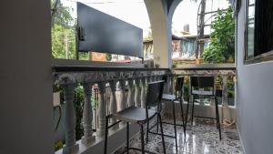 a bar with chairs on a balcony at SortBy Stays, Anjuna in Anjuna