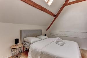 um quarto branco com uma cama e uma cadeira em Le Manet- Montigny em Montigny-le-Bretonneux