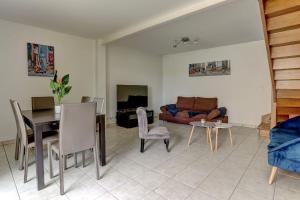 uma sala de estar com um sofá e uma mesa em Le Manet- Montigny em Montigny-le-Bretonneux