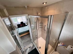 La petite salle de bains est pourvue d'une douche et de toilettes. dans l'établissement Ensuite Rooms Birmingham Underwood Close, à Birmingham