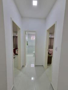 um quarto com paredes brancas e um corredor com portas em Sobrado a 200m da Praia e Orla, 02 QTS com ar condicionado em Aracaju