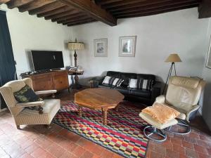 a living room with a couch and a table and chairs at Maison Lavande in Blismes