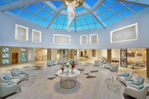 een grote lobby met banken en stoelen en een tafel bij Hilton Hurghada Plaza Hotel in Hurghada