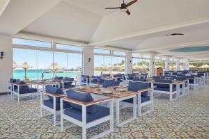 een eetkamer met tafels en stoelen en de oceaan bij Hilton Hurghada Plaza Hotel in Hurghada