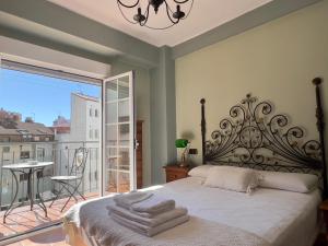 a bedroom with a bed and a balcony with a view at Housing León Marigold in León