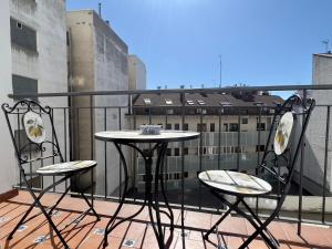 Balkon mit Tisch und 2 Stühlen in der Unterkunft Housing León Marigold in León