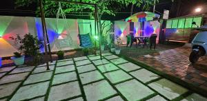 a patio with a table and an umbrella at night at Noel's beach homestay in Alleppey