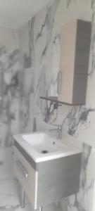 uma casa de banho com um lavatório branco e um espelho. em MALAK Tingis em Tânger
