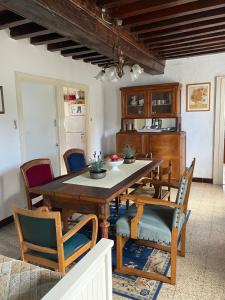 een eetkamer met een houten tafel en stoelen bij Maison Lavande in Blismes