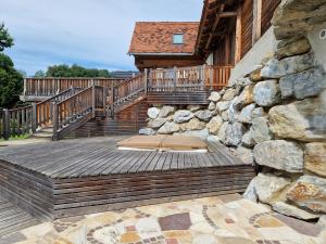 een houten terras met een trap en een stenen muur bij Janischhof 48 in Sankt Margarethen an der Raab